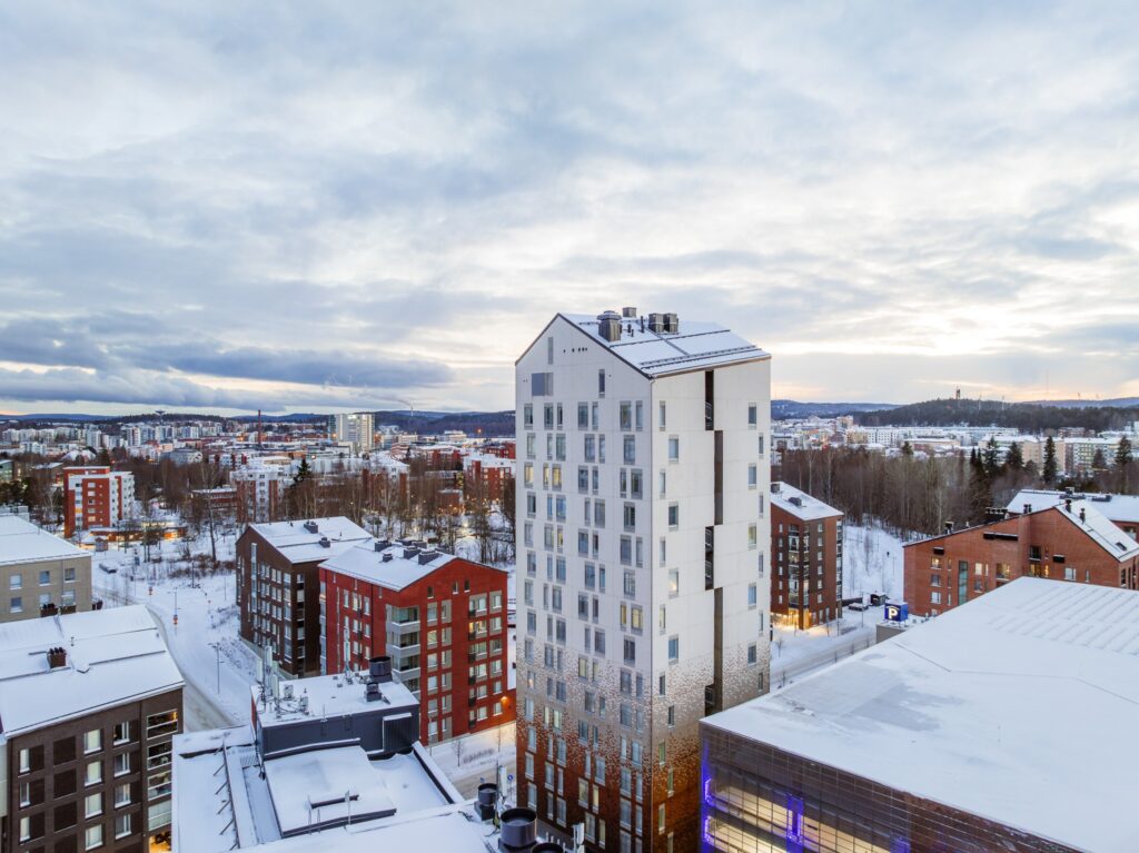 Kuvassa näkyy kaupunkimaisemaa, etualalla korkea kerrostalo.
