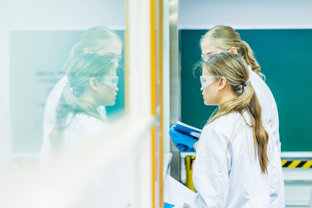 Kuvassa näkyy laboratoriossa kaksi ihmistä valkoisissa takeissa.