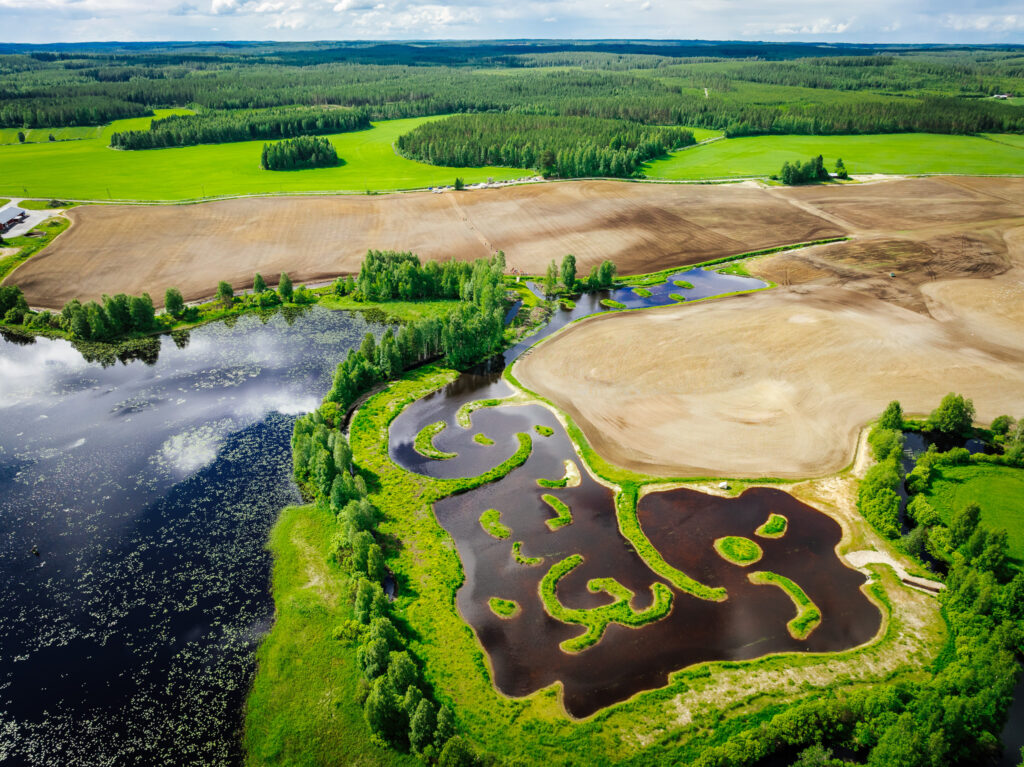 Ilmakuvassa vettä, peltoa ja metsää.