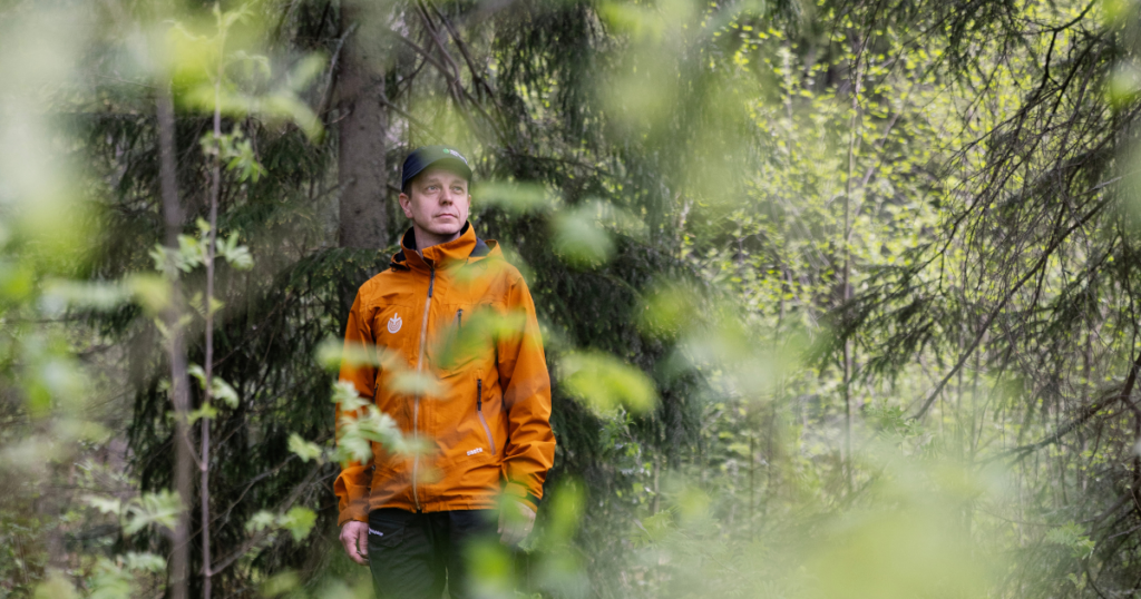 Lehvästön läpi näkyy oranssiin takkiin pukeutunut henkilö.